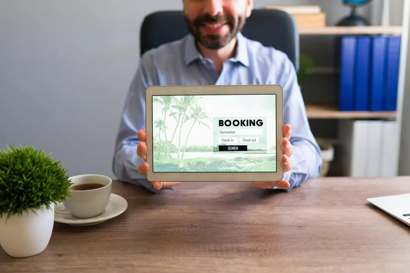 Agente de viajes feliz, sonriendo mientras sostiene una tableta que muestra una reserva de viaje. Representante de ventas mostrando información de viaje a un cliente en su oficina.